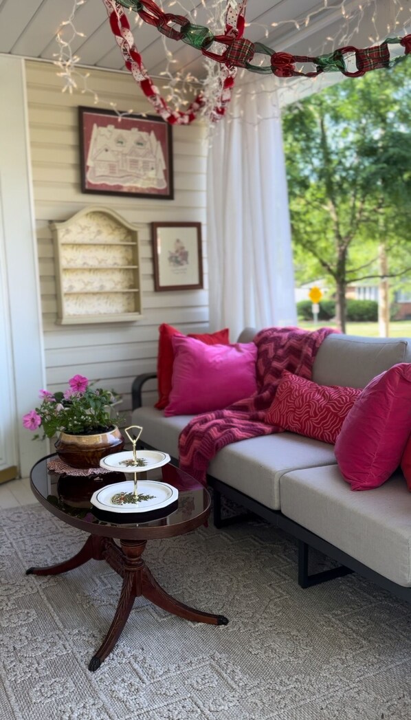 A cozy seating area with a sofa, pillows, and a small table with decorative items.