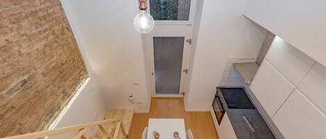 A compact kitchen with a dining table, a built-in stove, and a small window.