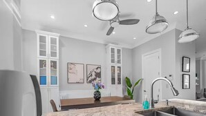 A modern kitchen with a marble countertop, a built-in sink, and a ceiling fan. - Gold Coast Pristine 5BR - 3.5BA - Patio - Parking (Chicago)