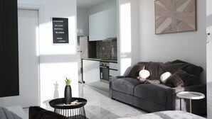 A modern living room with a sofa, a coffee table, and a painting on the wall.