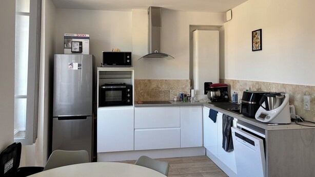 A compact kitchen with a refrigerator, microwave, oven, and dishwasher.