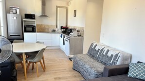 A compact living space with a dining area, kitchenette, and seating area.