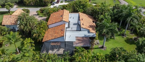 A residential area with multiple houses, including a house with a red-tiled roof and a large garden.