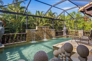 A pool area with a waterfall feature, stone balustrades, and a covered seating area. - Private Serene Florida Estate Near Beaches (Fort Myers)