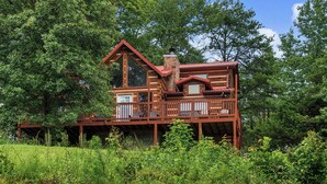 A cabin with a deck, surrounded by dense forest. - Welcome to Biltmore Escape, your perfect Sevierville retreat nestled in the hear (Sevierville)
