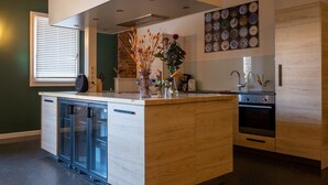 Una cocina moderna con una isla central, horno integrado y salpicadero decorado con platos.