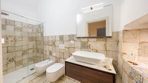 Une salle de bain avec une douche à parois de verre, un lavabo blanc et un miroir au-dessus du lavabo.