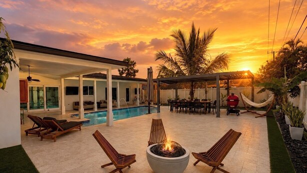 Um quintal com piscina, área de estar externa, lareira e churrasqueira.