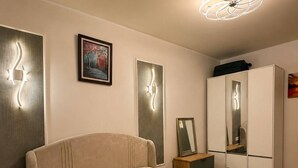 Een slaapkamer met een bed, nachtkastjes, een kledingkast en wandlampen.