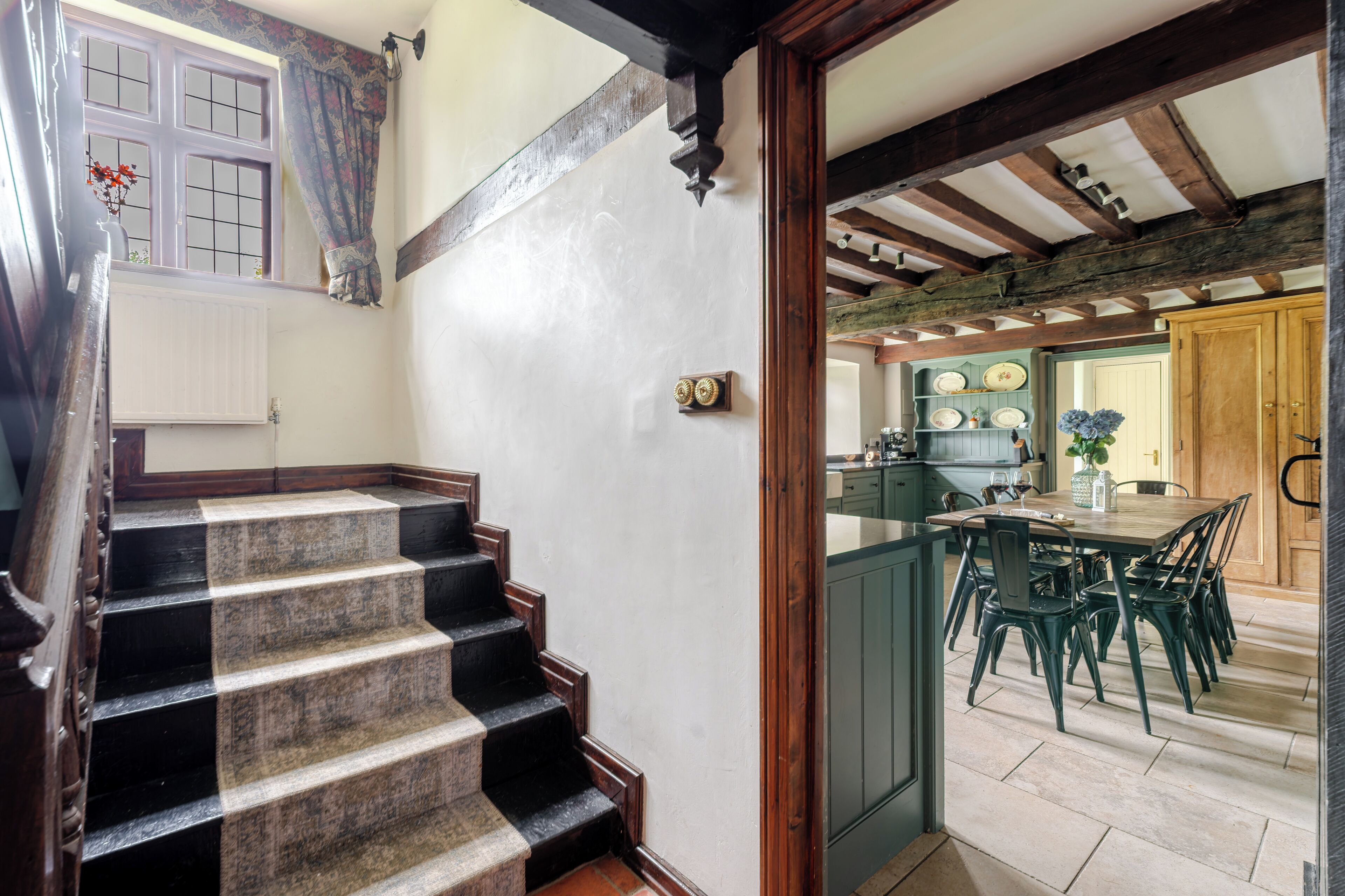 Una escalera que lleva a un comedor con vista a la cocina.
