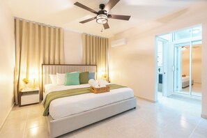 A bedroom with a bed, curtains, a ceiling fan, a nightstand, and a bedside table. - View of Pontezuela (Santiago de los caballeros)