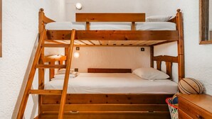 Een slaapkamer met een stapelbed, een nachtkastje en een basketbal.