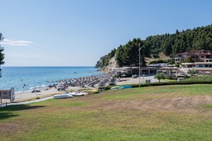 A coastal beach with umbrellas, sun loungers, and a clear sky. - Ieva Home by Rentals Pro - Elani Halkidiki (Elani)