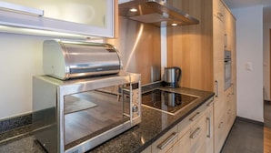 Eine moderne Küche mit einem Edelstahltoaster, einer Mikrowelle und einem Wasserkocher auf der Arbeitsfläche.