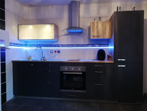 A modern kitchen with dark cabinetry, a built-in oven, and a microwave. - House for 4 people in a complex with a pool (Moliets-et-Maa)