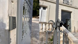 Una entrada cerrada con una reja metálica, un teclado y un sistema de seguridad GRIFEMA.