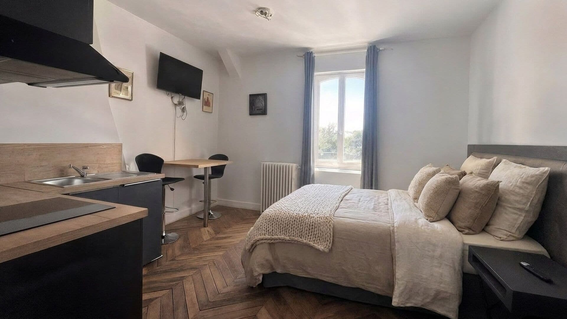 Ein modernes Schlafzimmer mit Bett, Nachttisch und Blick ins Freie.