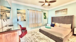 A bedroom with a bed, a desk, a chair, a ceiling fan, and artwork on the walls. - Family Retreat for 14 in Reunion Resort with Pool (Kissimmee)