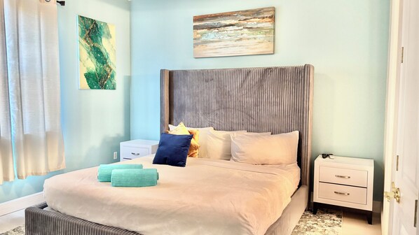A bedroom with a bed, pillows, a nightstand, and a wall art piece. - Family Retreat for 14 in Reunion Resort with Pool (Kissimmee)