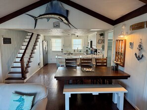 A nautical-themed interior with a wooden staircase, a dining area, and a kitchen. - Cana Front Beauty close to the Heart of OIB! (Ocean Isle Beach)