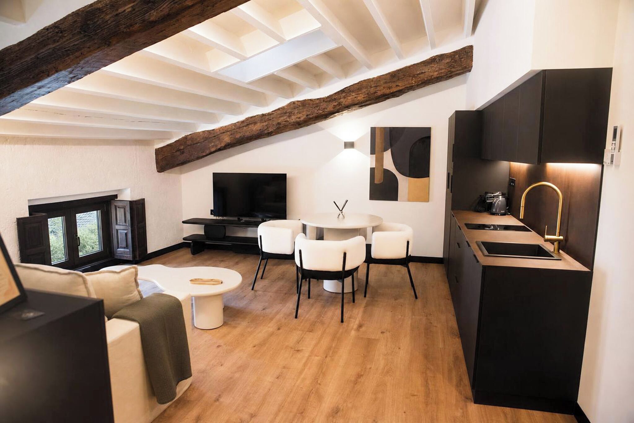 Un espacio habitable moderno con comedor, cocina y equipo de entretenimiento.