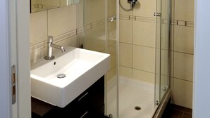 A bathroom with a glass-enclosed shower, a white sink, and a mirror. - Casa Gelsomino | Private terrace, 15-minute walk to Piazza Maggiore ⭐ (Bologna)