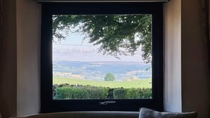 A window with a view of a green landscape, a chair, and a cushion. - Fox Cottage / Luxury 2 Bed (sleeps 4) with stunning views and 4 acre dog field (Matlock)