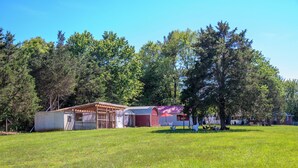 A rural property with a barn, a small shed, and a large tree.