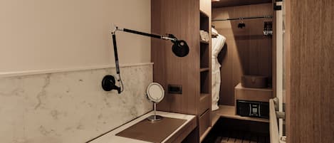 Un baño moderno con tocador, espejo y perchero.