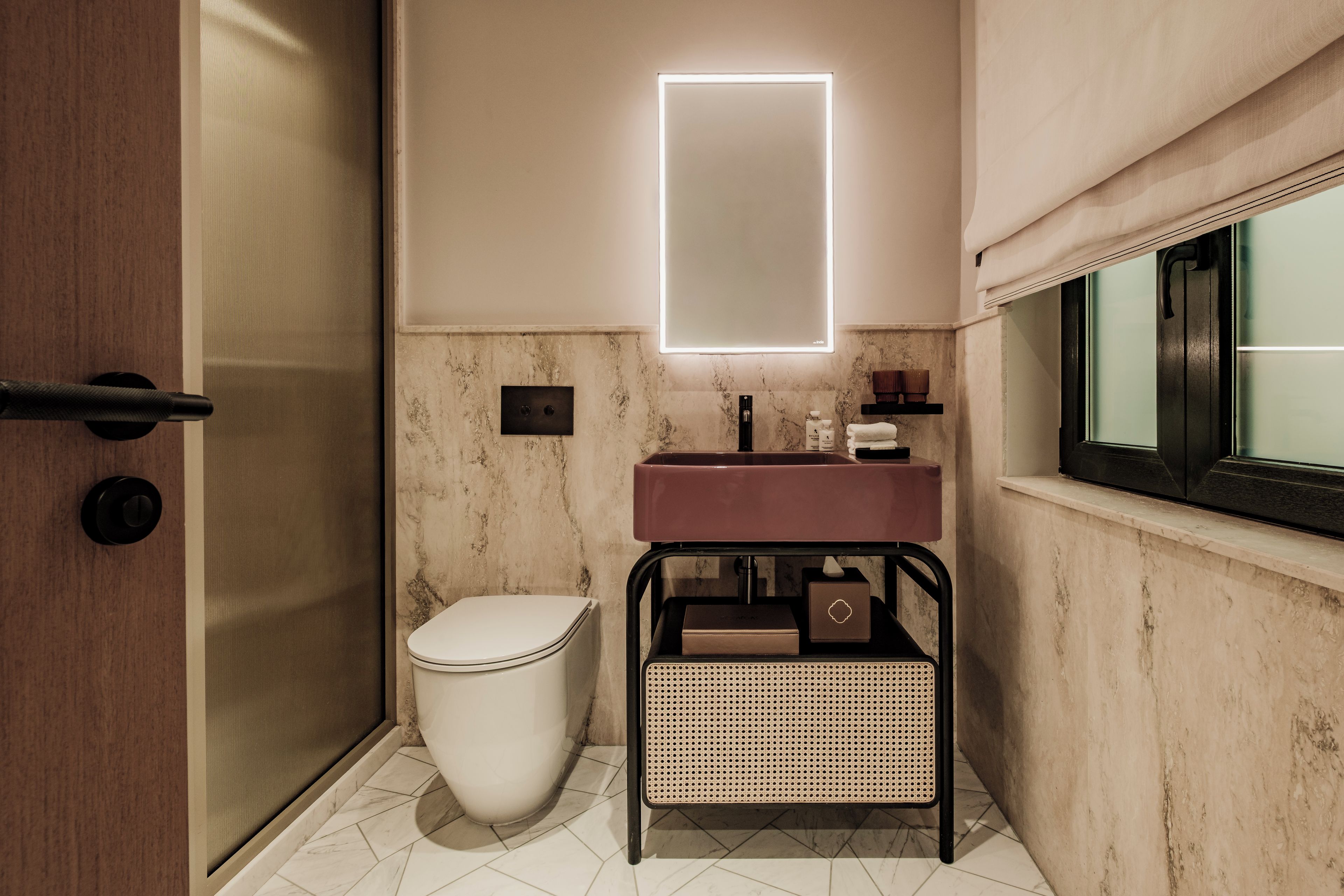 A modern bathroom with a toilet, sink, and mirror.
