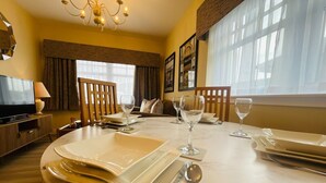A dining area with a table set for four, including plates, cutlery, and glasses.