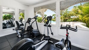 Un gimnasio con cintas de correr, bicicletas estáticas y máquinas elípticas.