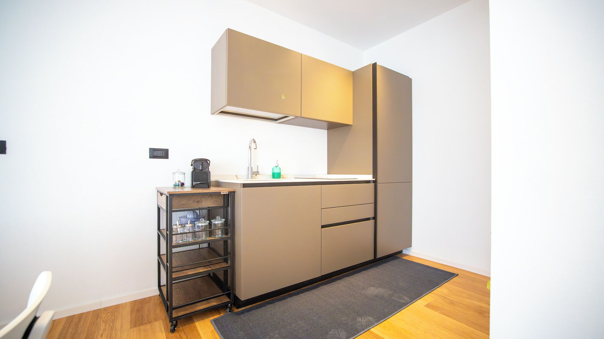 Una cocina compacta con horno integrado, un lavamanos y una pequeña encimera.