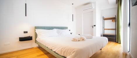 Un dormitorio moderno con cama, mesita de noche y armario.