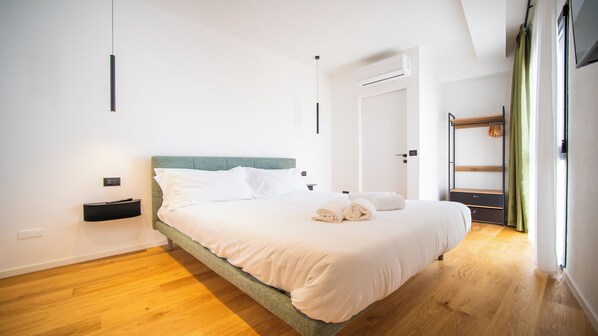 A modern bedroom with a bed, bedside table, and a wardrobe.
