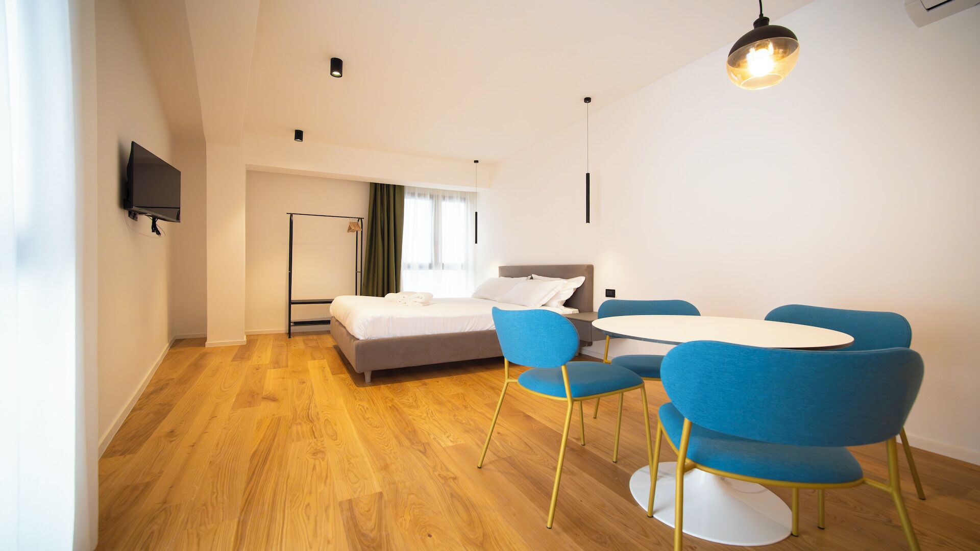 Ein modernes Zimmer mit einem Bett, einem Schreibtisch und Stühlen.