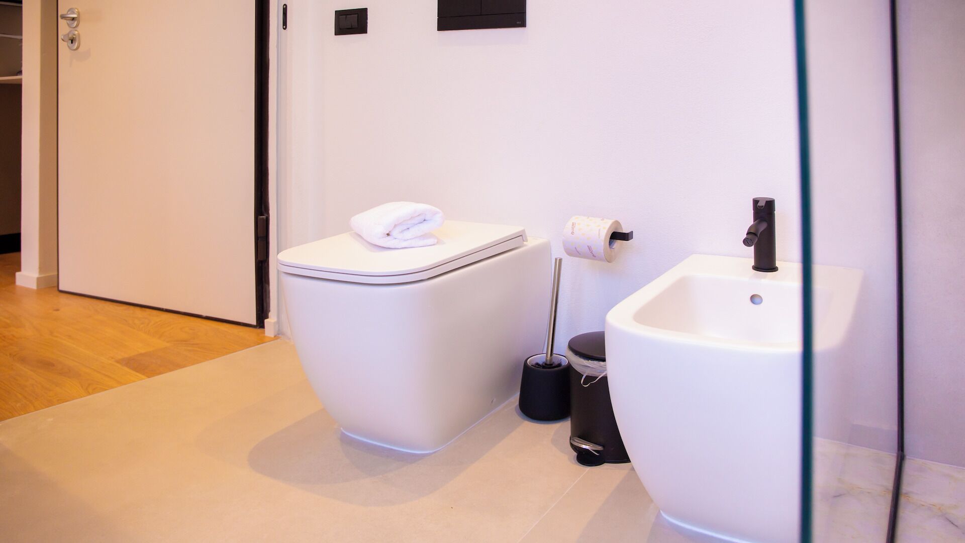 A modern bathroom with a toilet, bidet, and sink.