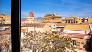 A cityscape with buildings, a prominent clock tower, and a dome structure. - Solemar Sicilia - Torre Maqueda (Palermo)