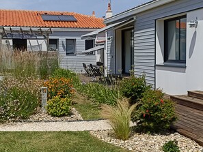 Il s’agit d’une propriété résidentielle dotée d’un patio, d’un espace extérieur aménagé pour s’asseoir et d’un jardin où l’on trouve diverses plantes et fleurs.