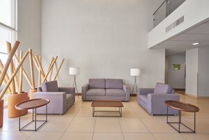 Una sala de estar moderna con un juego de sofá, dos mesas auxiliares y una mesa de centro.