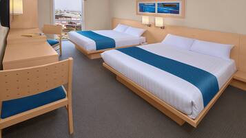 A hotel room with two beds, a desk, and a chair.