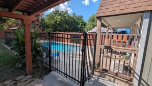 A pool area with a safety notice sign, a fenced pool, and a covered seating area. - 4BED Pool Down Town Home Near UMHB & SW Hospital (Belton)
