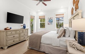A bedroom with a bed, dresser, TV, windows, and artwork. - Pet Friendly 30A Resort Retreat Near Beach, Pool, The Big Chill, with LSV (Inlet Beach)