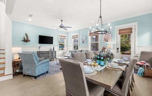 A dining area with a table set for four, a television mounted on the wall, and a ceiling fan. - Pet Friendly 30A Resort Retreat Near Beach, Pool, The Big Chill, with LSV (Inlet Beach)