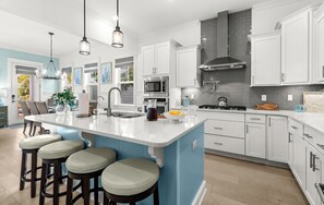 A modern kitchen with white cabinets, a central island with stools, stainless steel appliances, and pendant lighting. - Pet Friendly 30A Resort Retreat Near Beach, Pool, The Big Chill, with LSV (Inlet Beach)