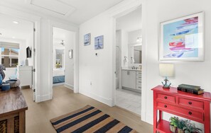 A modern kitchen with white cabinets, a red console table, and a framed painting above it. - Pet Friendly 30A Resort Retreat Near Beach, Pool, The Big Chill, with LSV (Inlet Beach)