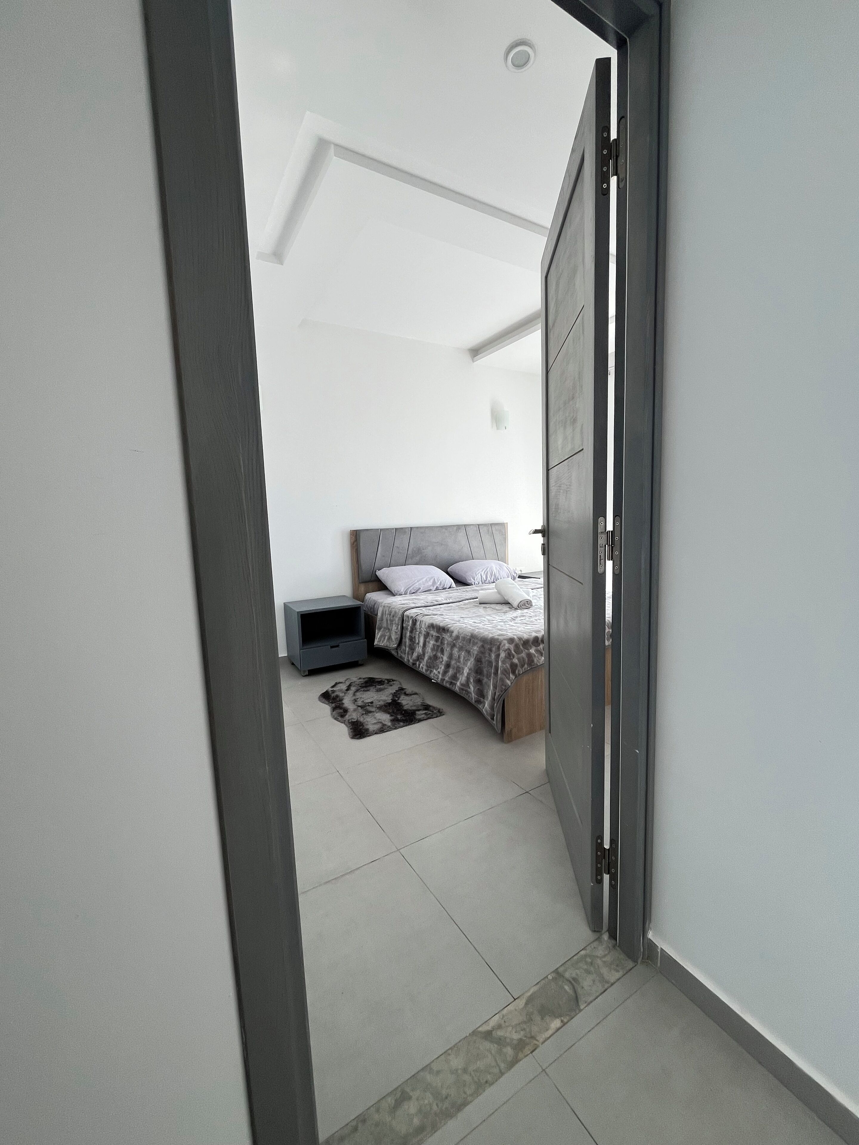 Ein Schlafzimmer mit einem Bett, einem Nachttisch und einem Teppich.