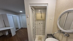 Ein Badezimmer mit Dusche, Waschbecken und Spiegel.