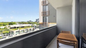 A balcony with a view of a cityscape, a table, and a chair. - Modern Luxury Studio, Rooftop Pool, Wynwood (Miami)