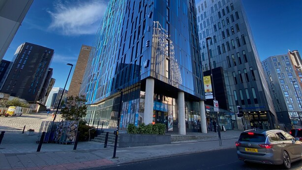 A modern high-rise building with a glass facade, surrounded by other tall buildings. - Student Only The View (Newcastle)